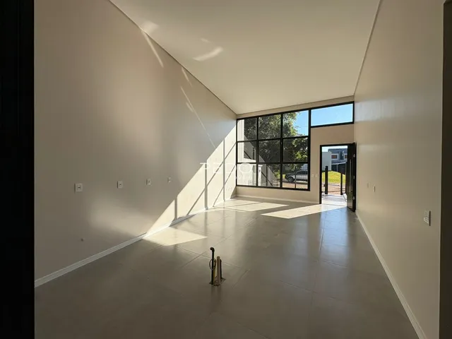 Espaço interno amplo com paredes brancas e piso claro.