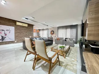 Sala de estar moderna com sofá e poltronas em um apartamento no Brasil.