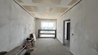 Interior de uma sala com paredes brancas e teto rebaixado.