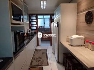 Foto de uma cozinha com armários brancos e eletrodomésticos em um imóvel.