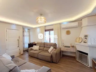 Sala de estar com sofá e lareira em ambiente claro.