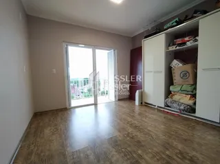 Sala de estar com piso de madeira e portas de vidro de correr.