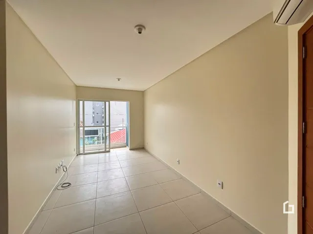 Vista de um corredor interno com piso de cerâmica claro.