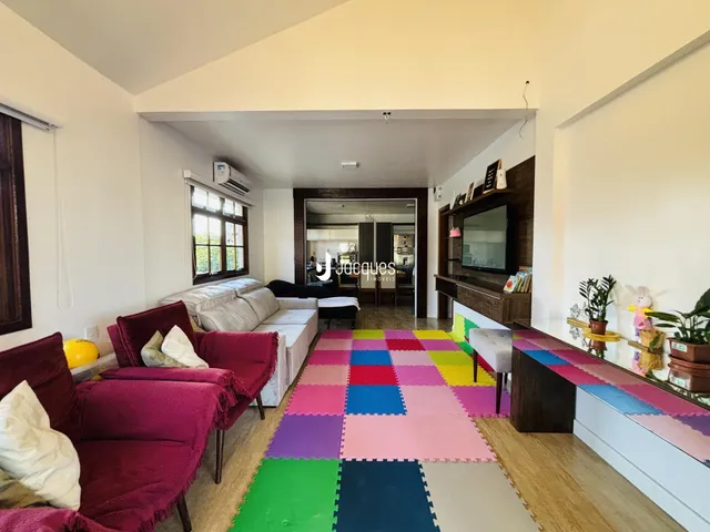 Sala de estar com piso de madeira e tapete colorido.