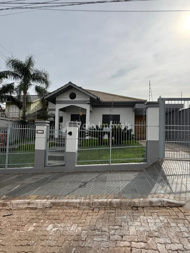 Fachada de uma residência em Lajeado, Brasil, com portão e cerca.