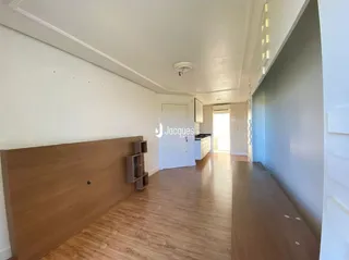 Corredor interno de uma residência com piso de madeira clara.