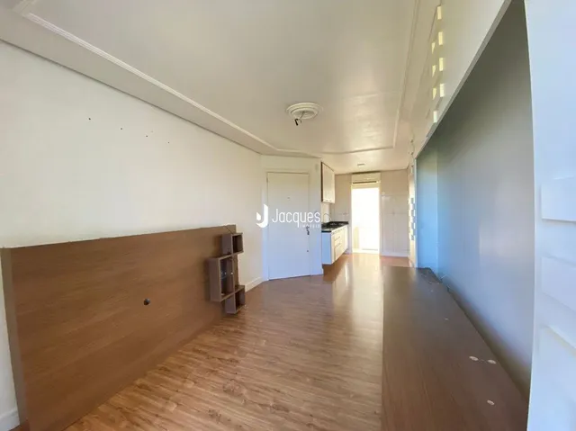 Corredor interno de uma residência com piso de madeira clara.