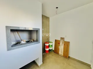 Interior de uma sala com nicho em uma parede e piso de cerâmica.