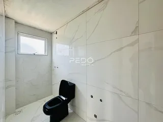 Foto de um ambiente interno com revestimento de azulejos brancos e um vaso sanitário.