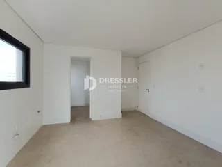 Interior de um ambiente com paredes brancas e piso claro.