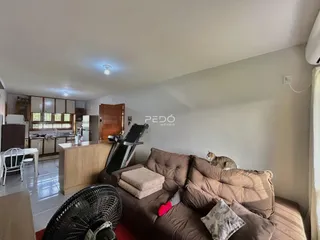 Sala de estar com sofá e equipamentos de ginástica em um apartamento.