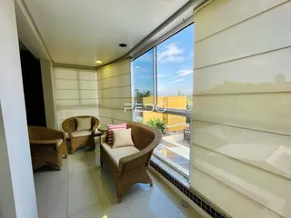 Sala de estar com vista para o exterior e grandes janelas.