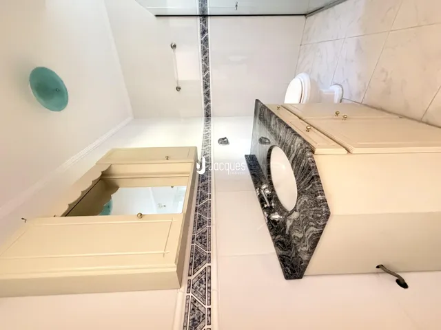 Foto de um banheiro moderno com revestimento de azulejos e bancada de mármore.
