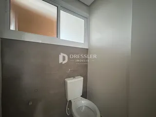 Foto de um ambiente interno mostrando um vaso sanitário e uma janela.