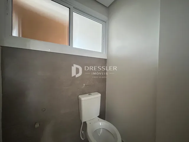 Foto de um ambiente interno mostrando um vaso sanitário e uma janela.