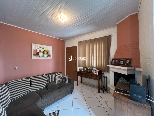 Sala de estar com sofá e lareira em um imóvel no Brasil.