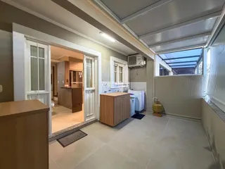 Hall de entrada com piso de cerâmica e porta de vidro em um imóvel em Lajeado.