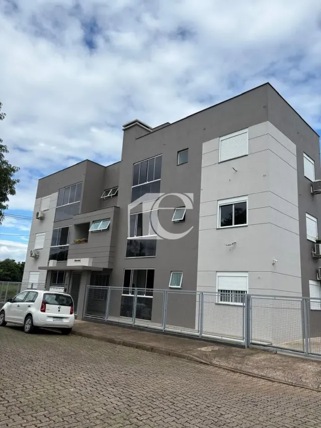 Fachada de um prédio residencial em Lajeado, Brasil, com revestimento cinza claro.