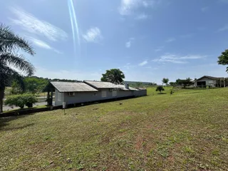 Foto da fachada de uma casa em Lajeado, Brasil, com um grande campo gramado.