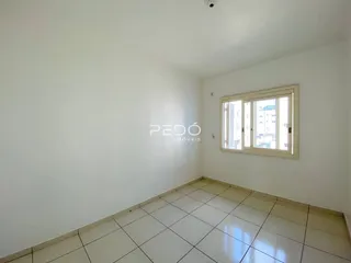 Foto de uma sala com piso de cerâmica clara e paredes brancas.