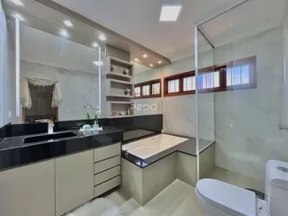Banheiro moderno com banheira e box de vidro em um imóvel.
