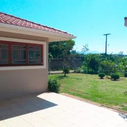 Foto de uma área externa com gramado e piso de cerâmica em uma propriedade.