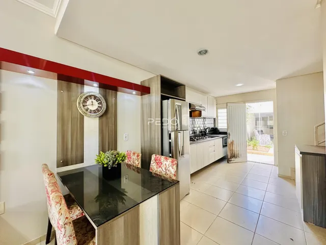 Ambiente de sala de estar e cozinha com bancada em primeiro plano.