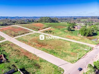 Vista aérea de um terreno rural com estradas de terra e vegetação.