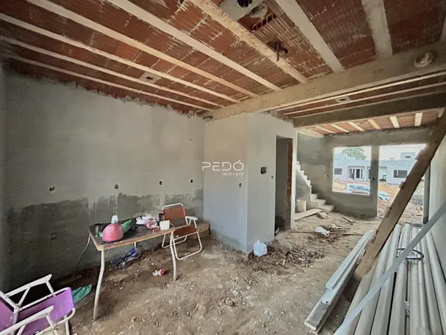 Imagem de um cômodo interno em construção com teto de madeira exposto.