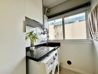Foto de uma cozinha com armários brancos e janela em Lajeado, Brasil.