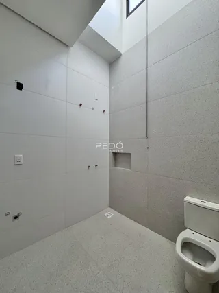 Foto de um ambiente interno com paredes brancas e piso claro.