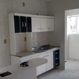 Uma cozinha com armários brancos e bancada clara é visível na propriedade.