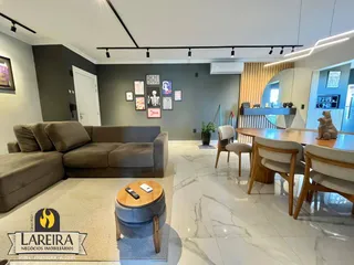 Sala de estar moderna com sofá e mesa de jantar em um imóvel no Brasil.