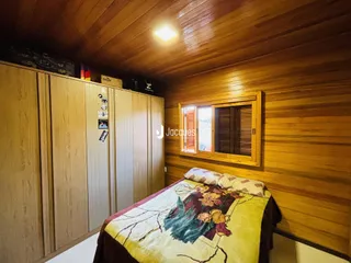 Quarto com paredes de madeira e armários embutidos.
