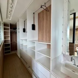 Hall de entrada com prateleiras embutidas brancas.