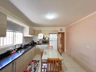 Foto da cozinha com armários e mesa de jantar em um imóvel em Lajeado.