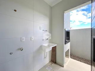 Foto de um banheiro com bancada e abertura para o exterior.