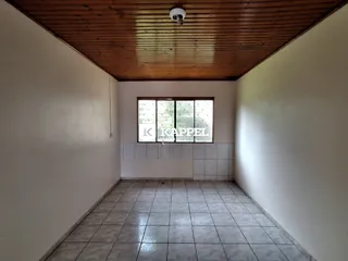 Ambiente interno com piso de cerâmica e teto de madeira em uma sala.