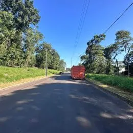 Vista de uma estrada asfaltada ladeada por vegetação verde.