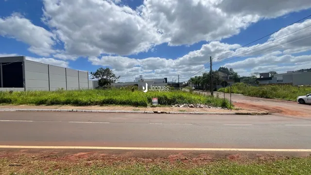 Vista externa de um prédio industrial em Lajeado, Brasil, com área verde e estrada em primeiro plano.