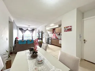Sala de jantar iluminada com vista para a cozinha em um imóvel no Brasil.