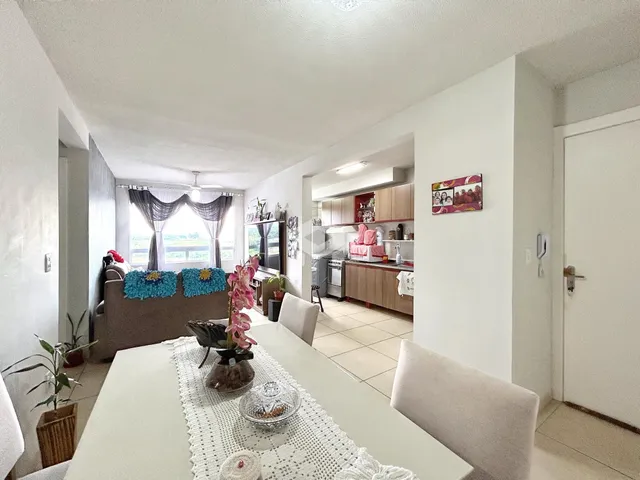 Sala de jantar iluminada com vista para a cozinha em um imóvel no Brasil.