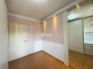 Vista interna de um ambiente com piso de madeira e parede decorada.