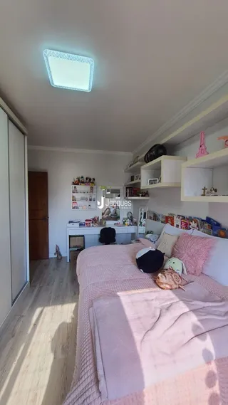 Quarto com cama e piso de madeira em um imóvel no Brasil.