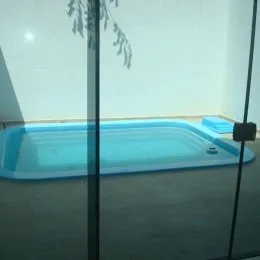 Foto de uma área com uma estrutura azul clara, possivelmente uma banheira ou piscina interna.