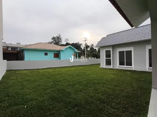Fachada de duas casas em Lajeado com gramado verde.