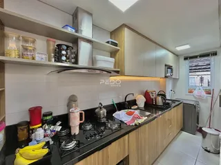 Cozinha moderna com armários e bancadas escuras.