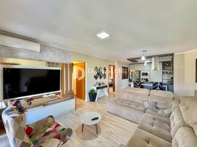 Sala de estar com sofá e televisão em um apartamento.
