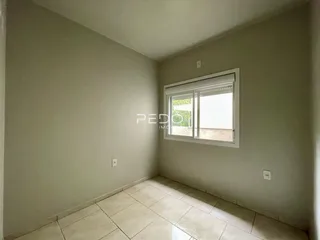 Interior de um cômodo com piso de cerâmica e janela.