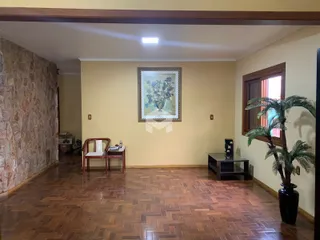 Sala de estar com piso de madeira e parede de pedra.